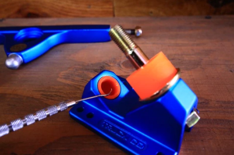 A blue tool is sitting on top of a wooden table.