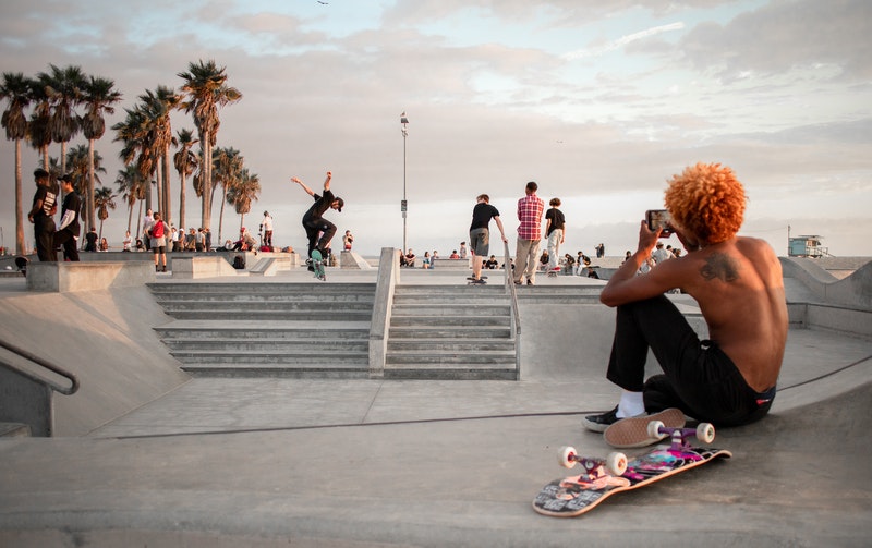 A skateboarder lounges at a skate park.